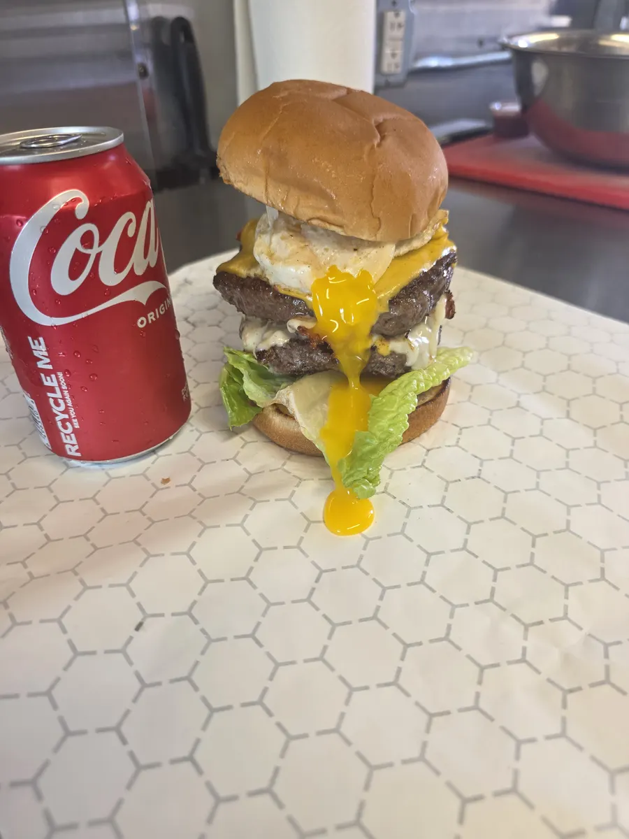 The finished Big Boss Burger with the fried egg yolk running down the front