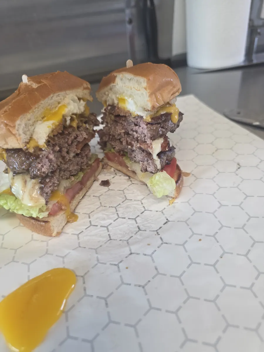The Big Boss Burger cut in half, showing two patties, hotlink and fried egg through the middle