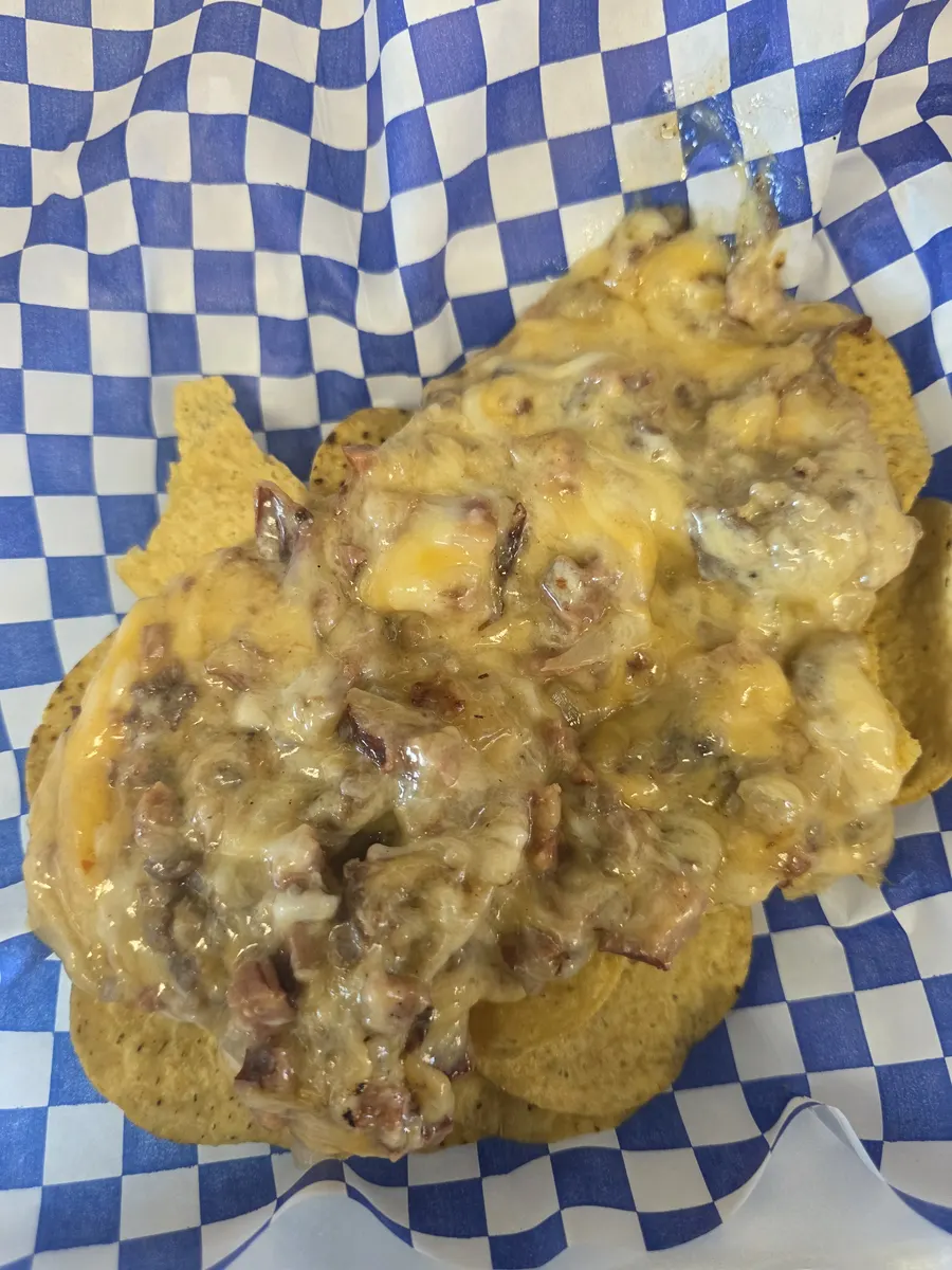 The melted cheese, sirloin and hotlink poured over the chips